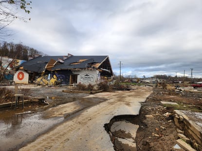 an Asheville business and part of a road damaged significantly by Hurricane Helene