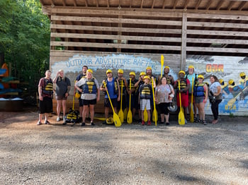 team members with their oars posing for a picture